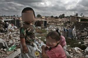 Niños con el rostro pixelado en un basural o asentamiento precario, imagen de la nota "Casi 5 millones de niños, niñas y adolescentes son «doblemente pobres» en la Argentina, según informe".