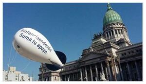 Globo aerostático con la leyenda "#infanciaendeuda, suma tu apoyo" frente al Congreso de la Nación.